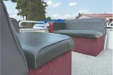 Slide: The Image of 2000 Tahoe Pontoon boat interior with gray seating and outdoor backdrop. - 13