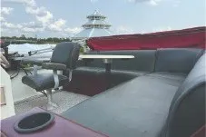 Slide: The Image of 2000 Tahoe Pontoon boat interior with seating and table under a clear sky. - 11