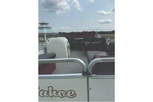 Slide: The Image of 2000 Tahoe Pontoon boat with seating, under a partly cloudy sky. - 10