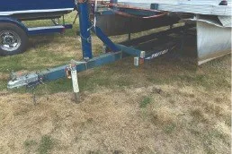 Slide: The Image of 2000 Tahoe Pontoon trailer parked on grass, showcasing hitch and frame. - 6
