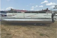 The Image of 2000 Tahoe Pontoon boat on grassy area under cloudy sky. - 1