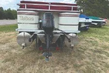 Slide: The Image of 2000 Tahoe Pontoon boat with outboard motor on grassy area. - 5