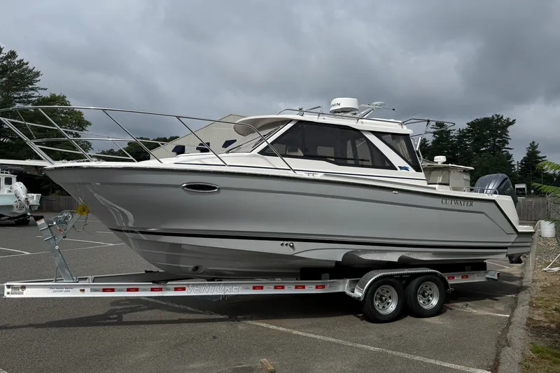 Slide: The Image of 2026 Cutwater C-248 Coupe boat on trailer in parking lot, overcast sky. - 3