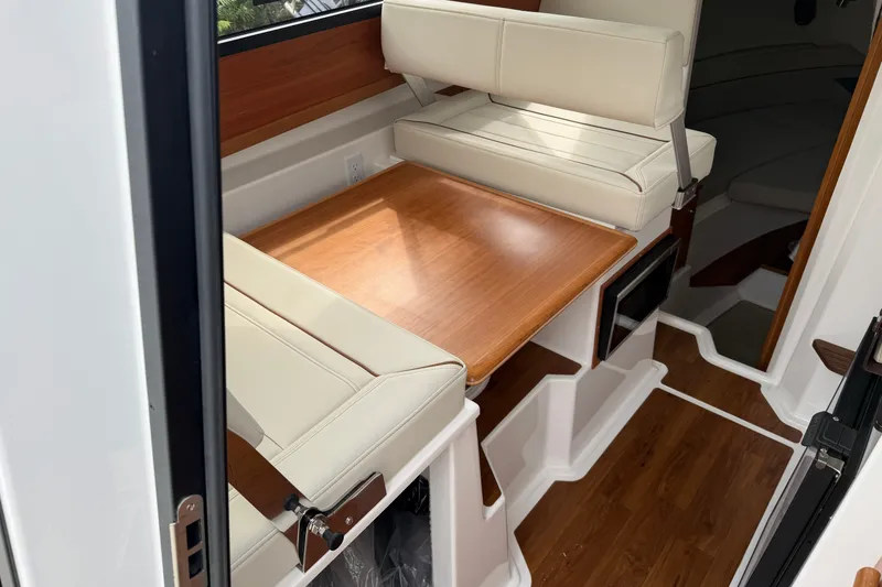 Slide: The Image of 2026 Cutwater C-248 Coupe interior with wooden table and cream seating. - 11