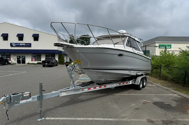 Slide: The Image of 2026 Cutwater C-248 Coupe boat on trailer in parking lot, overcast sky. - 2