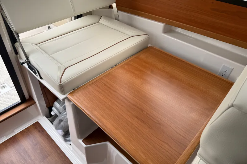 Slide: The Image of Interior of 2026 Cutwater C-248 Coupe featuring a wooden table and cushioned seating. - 16