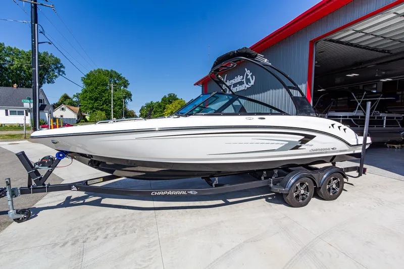 The Image of 2026 Chaparral 23 SSi boat on trailer outside a marina, sunny day. - 1