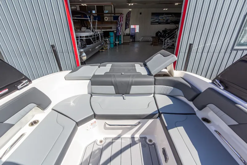 Slide: The Image of 2026 Chaparral 23 SSi boat interior with gray seating, docked in a garage. - 18