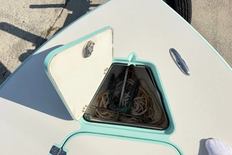 Slide: The Image of Open anchor hatch on 2023 Egret 21 Moccasin boat, revealing ropes and anchor. - 42