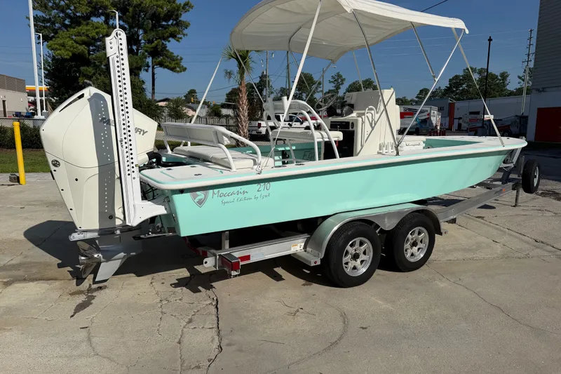 Slide: The Image of 2023 Egret 21 Moccasin boat on trailer, featuring a Mercury engine and canopy. - 47
