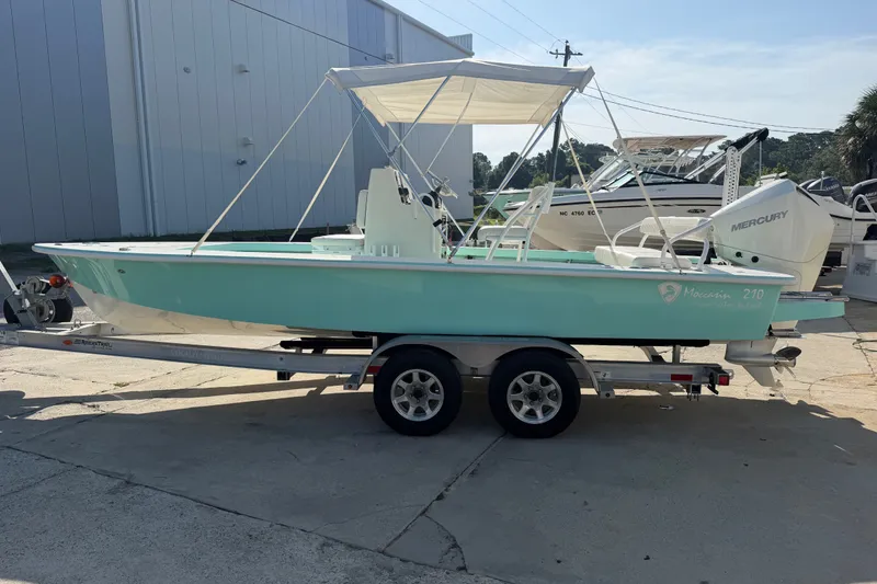 Slide: The Image of 2023 Egret 21 Moccasin boat on trailer, featuring Mercury outboard engine. - 49
