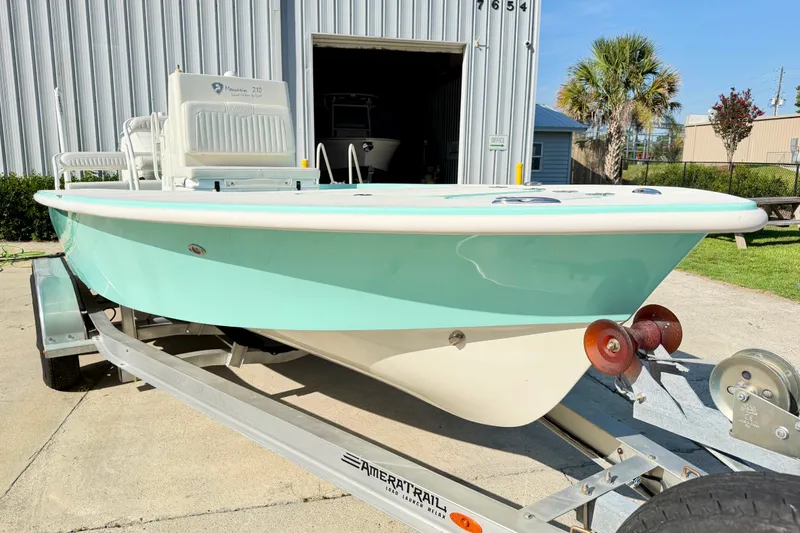 Slide: The Image of 2023 Egret 21 Moccasin boat on trailer, light blue hull, parked outdoors. - 13