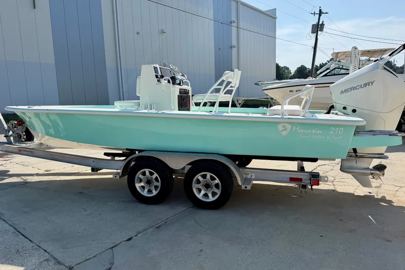 Slide: The Image of 2023 Egret 21 Moccasin boat on trailer, light blue hull, parked outdoors. - 18