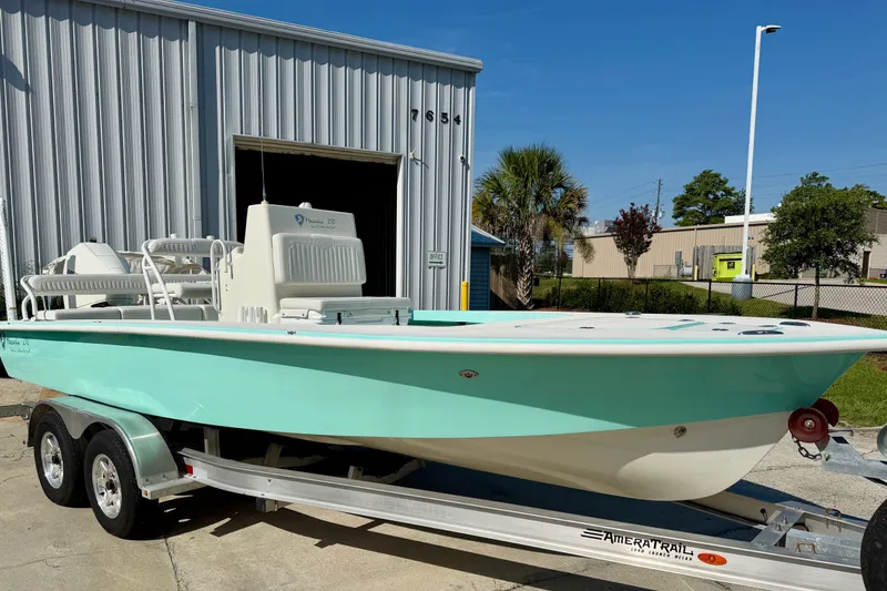 Slide: The Image of 2023 Egret 21 Moccasin boat on trailer, parked outside industrial building. - 19