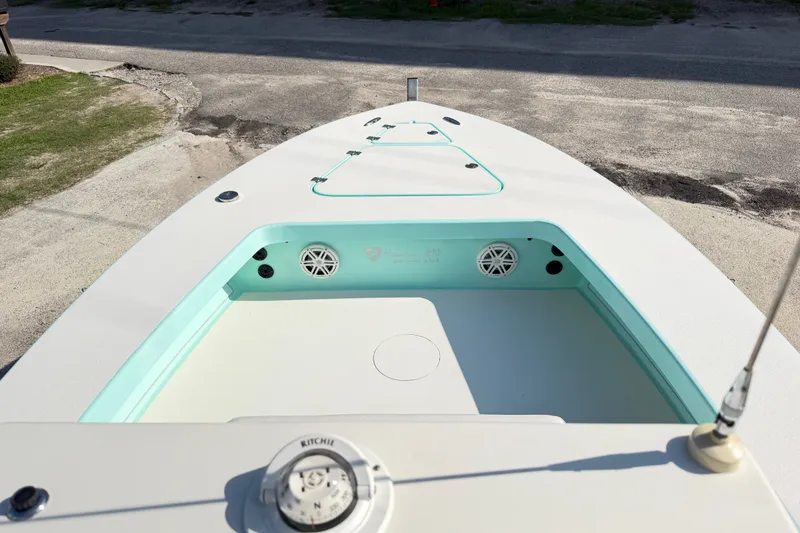 Slide: The Image of 2023 Egret 21 Moccasin boat deck with speakers and storage compartments. - 27