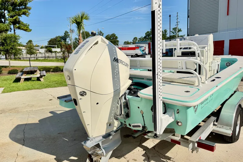 Slide: The Image of 2023 Egret 21 Moccasin boat with Mercury engine on trailer, parked outdoors. - 17