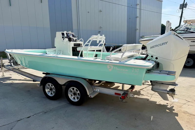 Slide: The Image of 2023 Egret 21 Moccasin boat with Mercury engine on trailer, light blue color. - 22