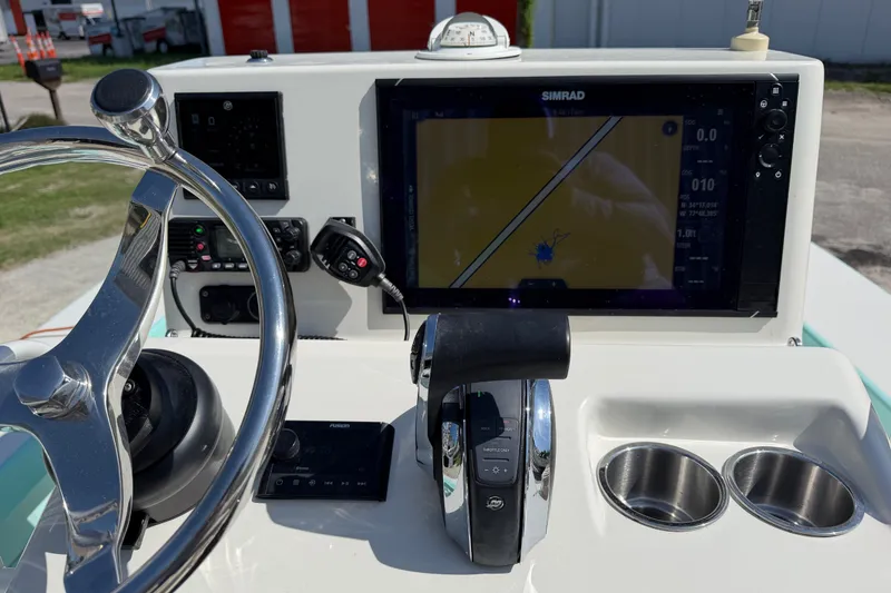 Slide: The Image of Boat dashboard with steering wheel, navigation screen, and controls on a 2023 Egret 21 Moccasin. - 34