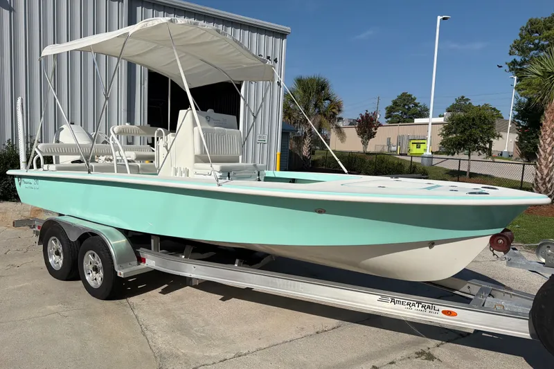 Slide: The Image of 2023 Egret 21 Moccasin boat with canopy on trailer, parked outdoors. - 48