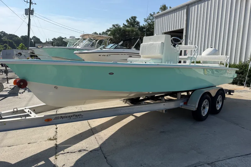 The Image of 2023 Egret 21 Moccasin boat on trailer, parked outdoors near other boats. - 0