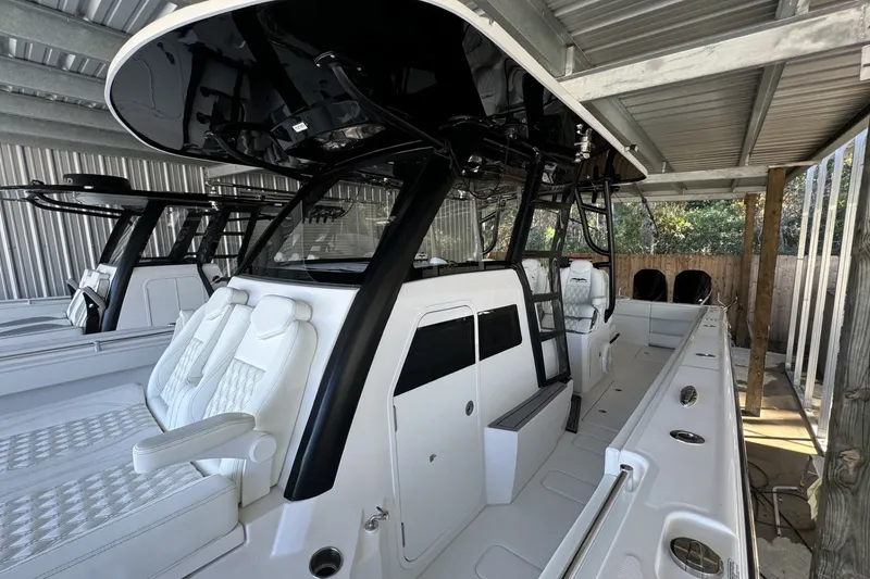Slide: The Image of 2024 Invincible 38 Catamaran with sleek design and luxurious seating in a covered dock. - 5