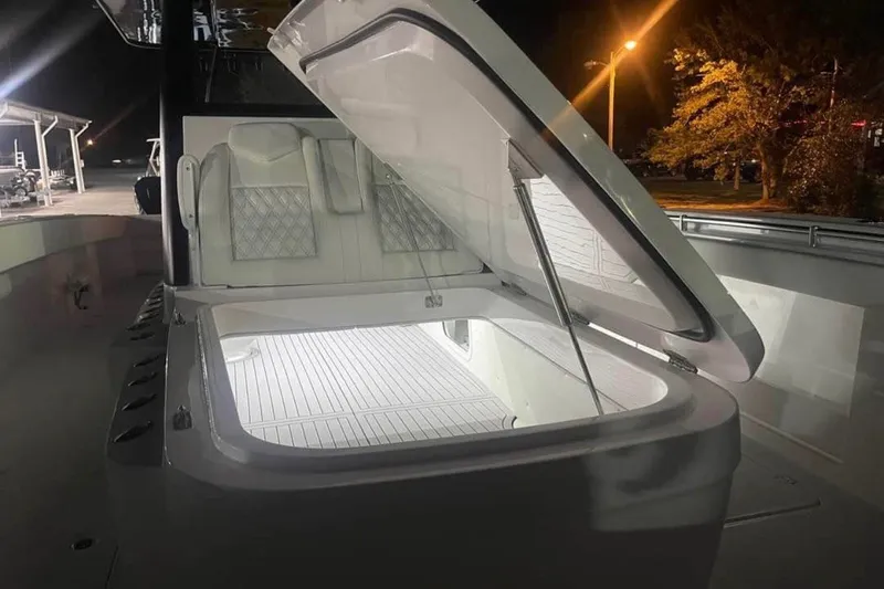 Slide: The Image of Open storage compartment on 2024 Invincible 38 Catamaran, illuminated at night. - 7