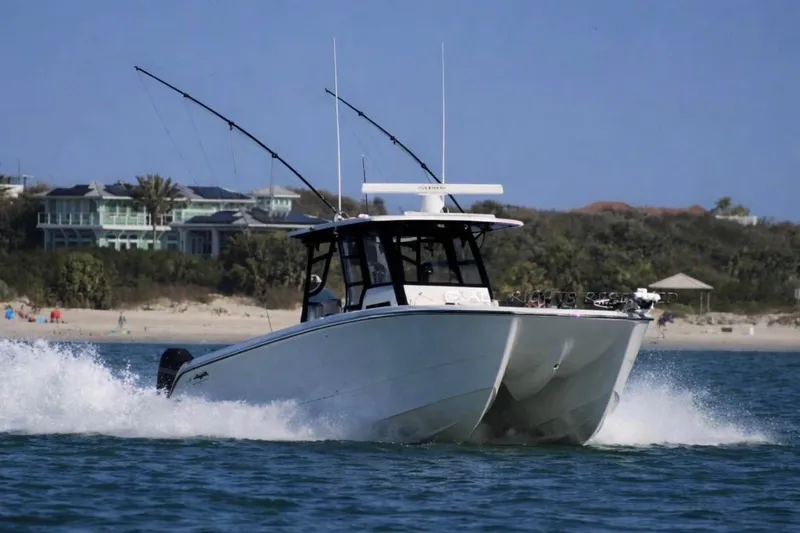 Slide: The Image of 2024 Invincible 38 Catamaran cruising on water near a coastal landscape. - 2