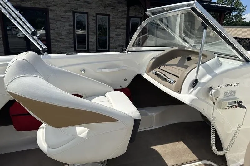 Slide: The Image of Interior of a 2006 Larson 180 I/O boat with white seating and dashboard. - 6