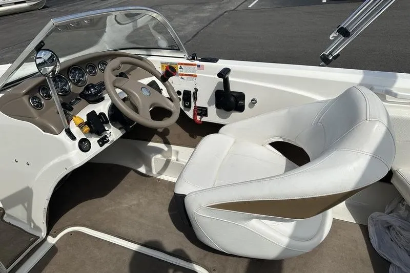Slide: The Image of 2006 Larson 180 I/O boat interior with steering wheel and white captain's seat. - 9