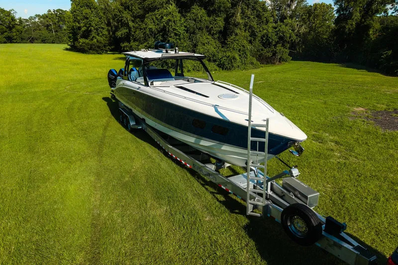 Slide: The Image of 2020 Concept 44' Cuddy Cabin boat on trailer in grassy field. - 13