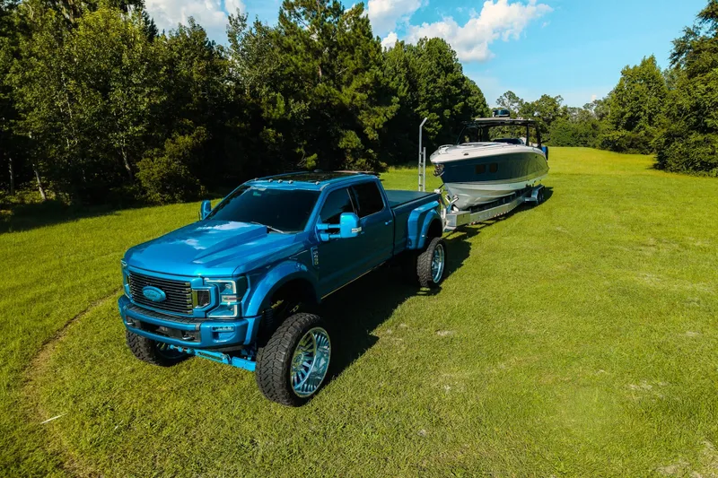 Slide: The Image of Blue truck towing 2020 Concept 44' Cuddy Cabin boat on grassy field. - 7