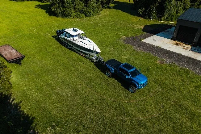 Slide: The Image of Aerial view of a blue truck towing a 2020 Concept 44' Cuddy Cabin boat on grass. - 15