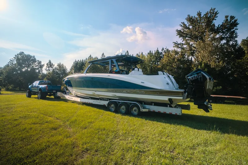 Slide: The Image of 2020 Concept 44' Cuddy Cabin boat on trailer, towed by a blue truck in grassy field. - 4