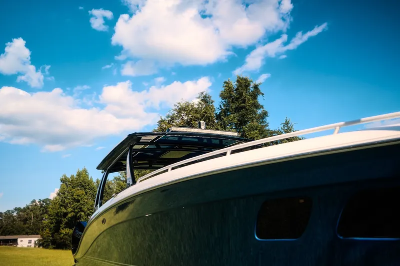 Slide: The Image of 2020 Concept 44' Cuddy Cabin boat under a clear blue sky with trees in the background. - 21