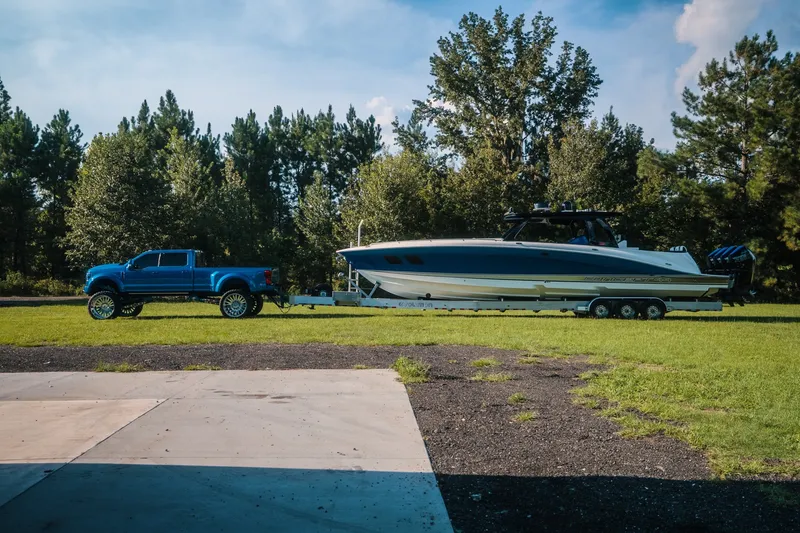 Slide: The Image of Blue truck towing 2020 Concept 44' Cuddy Cabin boat on grassy area with trees. - 3