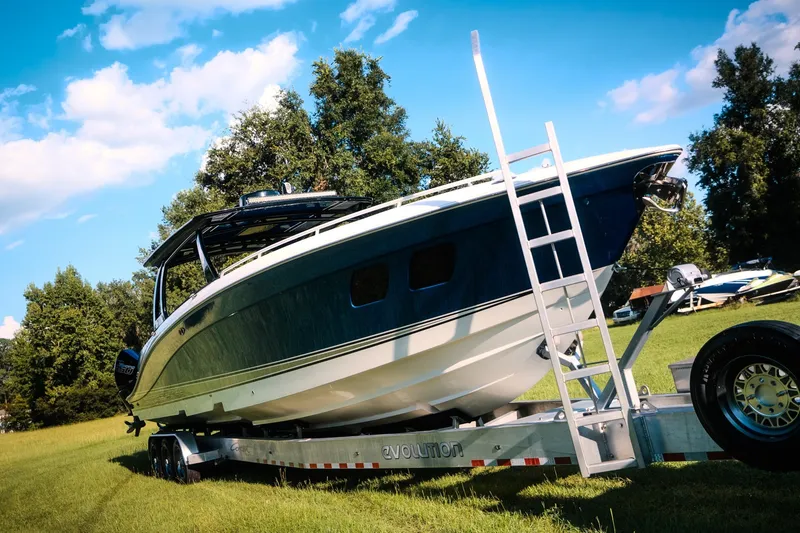 Slide: The Image of 2020 Concept 44' Cuddy Cabin boat on trailer in grassy area, under blue sky. - 14