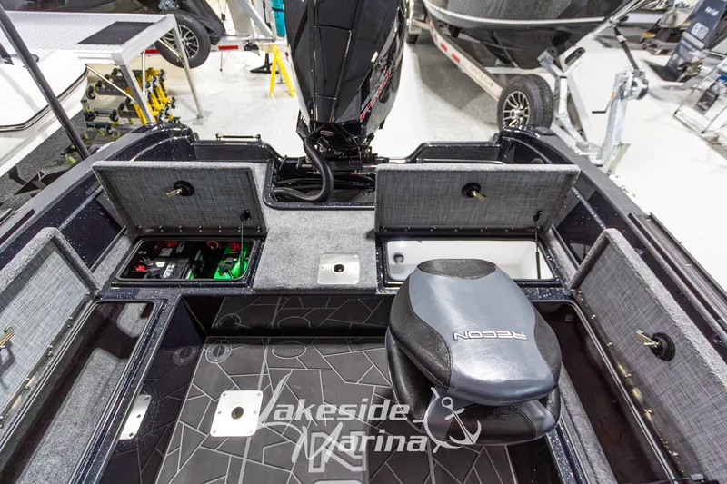 Slide: The Image of 2027 Recon 985 DC boat interior with storage compartments and seating at Lakeside Marina. - 17