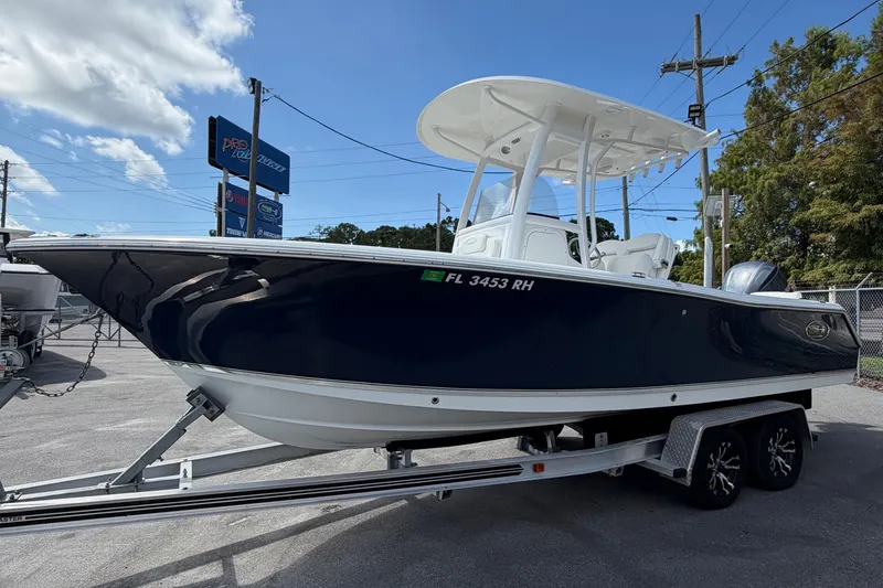 Slide: The Image of 2017 Sea Hunt Ultra 235SE boat on trailer, parked outdoors under a blue sky. - 3