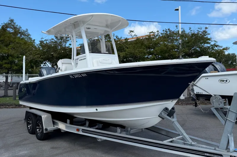 The Image of 2017 Sea Hunt Ultra 235SE boat on trailer, parked outdoors under blue sky. - 0