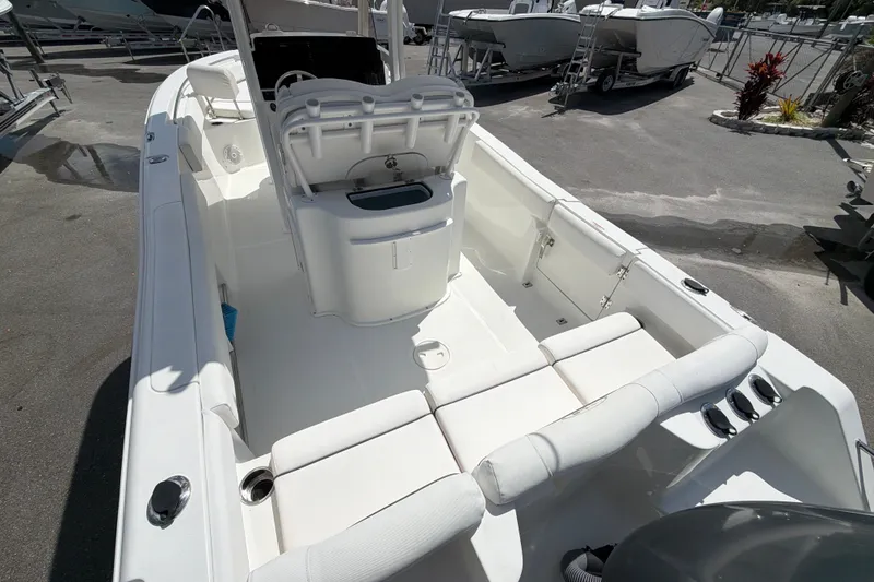 Slide: The Image of 2017 Sea Hunt Ultra 235SE boat interior with seating and console, parked outdoors. - 5