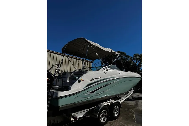 Slide: The Image of 2024 Hurricane SunDeck 2486 OB boat on trailer under clear blue sky. - 2