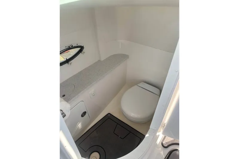 Slide: The Image of 2024 Hurricane SunDeck 2486 OB boat interior with compact bathroom and toilet. - 7