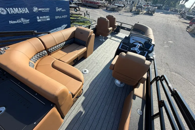 Slide: The Image of Luxurious 2027 Ranger 220FC pontoon boat with tan seating and modern dashboard. - 15