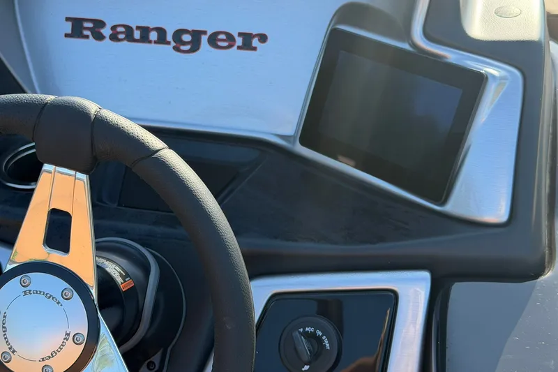 Slide: The Image of Steering wheel and dashboard of 2027 Ranger 220FC boat, featuring modern controls. - 14