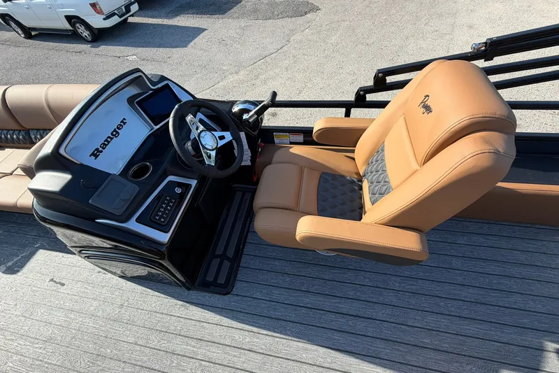 Slide: The Image of 2027 Ranger 220FC boat interior with tan captain's chair and steering console. - 10