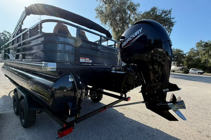 Slide: The Image of 2027 Ranger 220FC pontoon boat with Mercury outboard motor, parked on a trailer. - 29