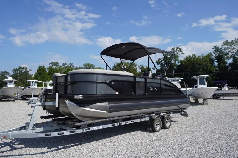 Slide: The Image of 2024 Barletta Cabrio 22UC pontoon boat on trailer, parked outdoors under blue sky. - 1