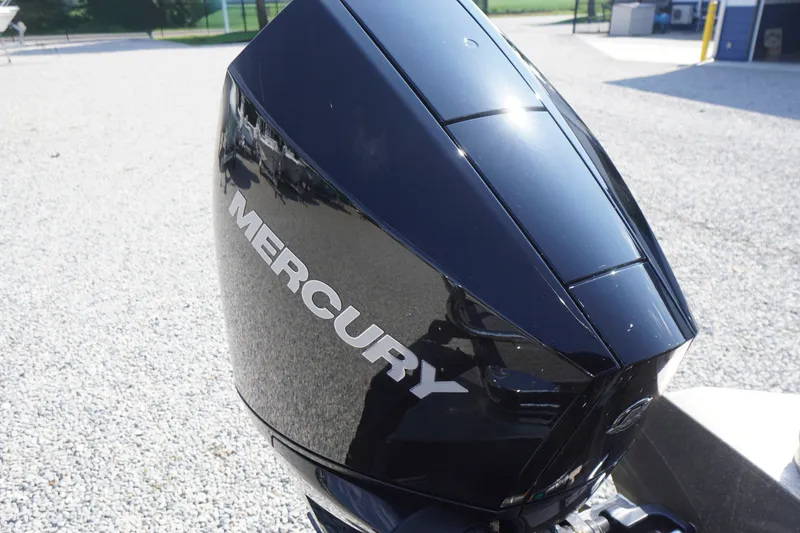 Slide: The Image of Mercury outboard motor on 2024 Barletta Cabrio 22UC boat, parked on gravel. - 47