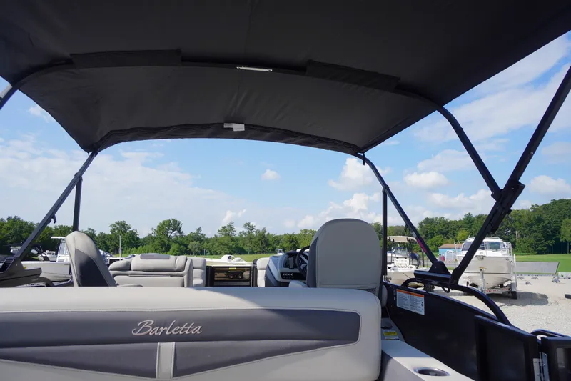 Slide: The Image of 2024 Barletta Cabrio 22UC pontoon boat interior with canopy, showcasing luxury seating and open sky. - 42
