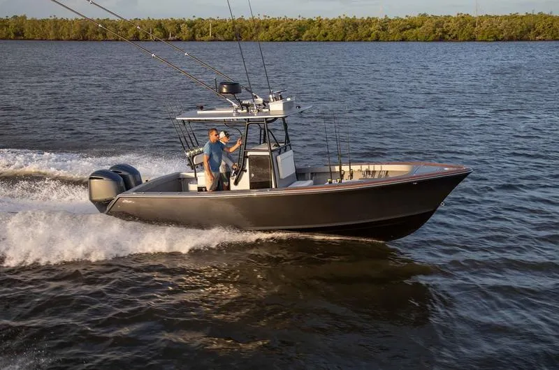 The Image of 2020 Stuart 27 CC boat cruising on a lake with a person steering. - 2